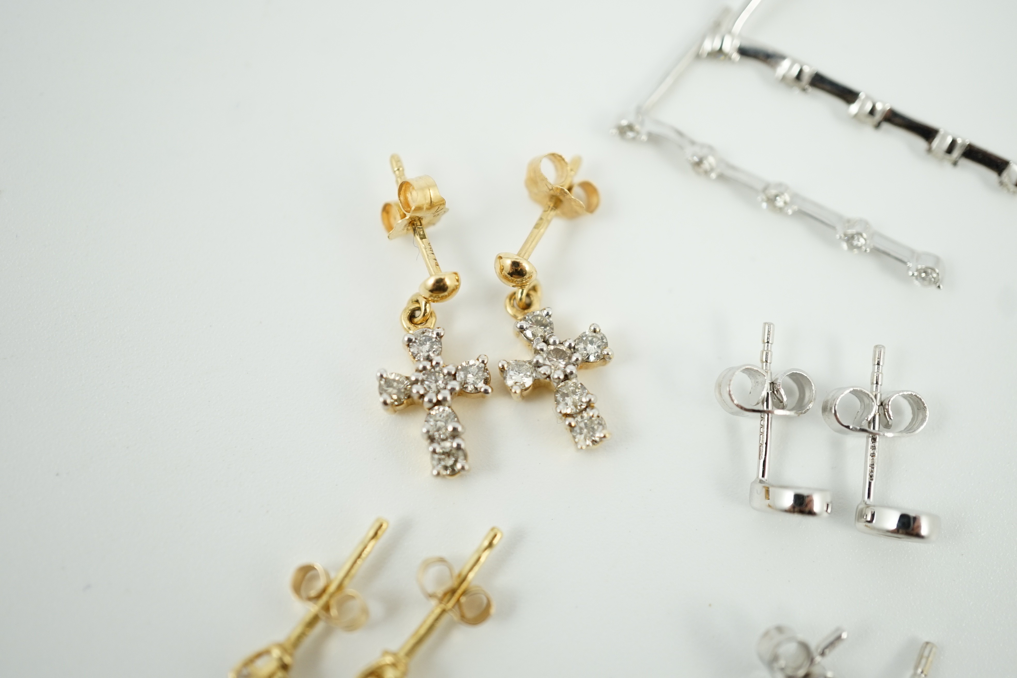 Three pairs of 18ct white gold and diamond set ear rings, including solitaire ear studs and two other pairs of 18ct gold and diamond set ear studs including cross, largest 24mm, gross weight 6.4 grams.